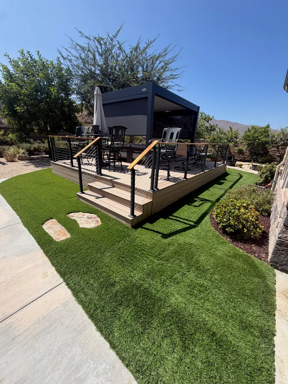 Artificial turf surrounding a raised deck and covered outdoor seating area in Rocklin